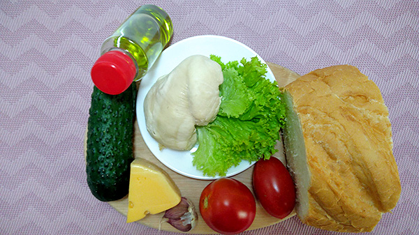 Ситний салат з курячим філе, твердим сиром, помідорами, огірком та грінками