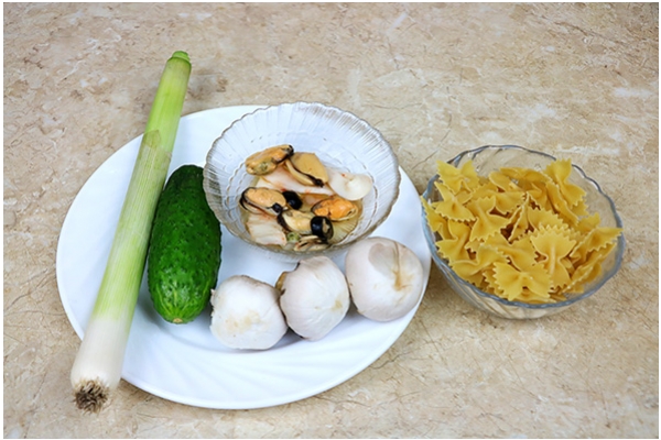 Пікантний салат з мідіями, цибулею-порей, шампіньйонами, огірком та макаронами